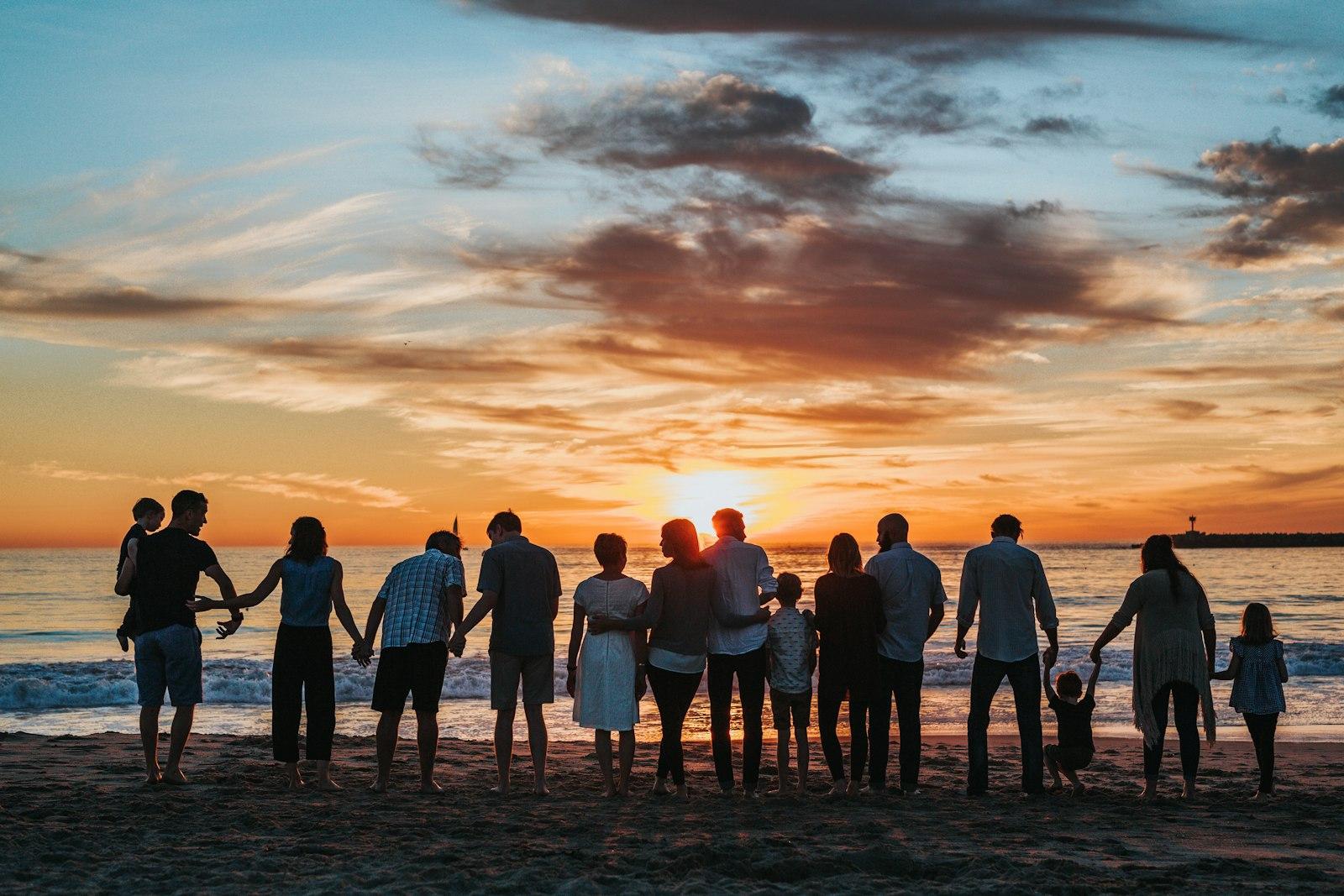 Family walking together along a beach at sunset