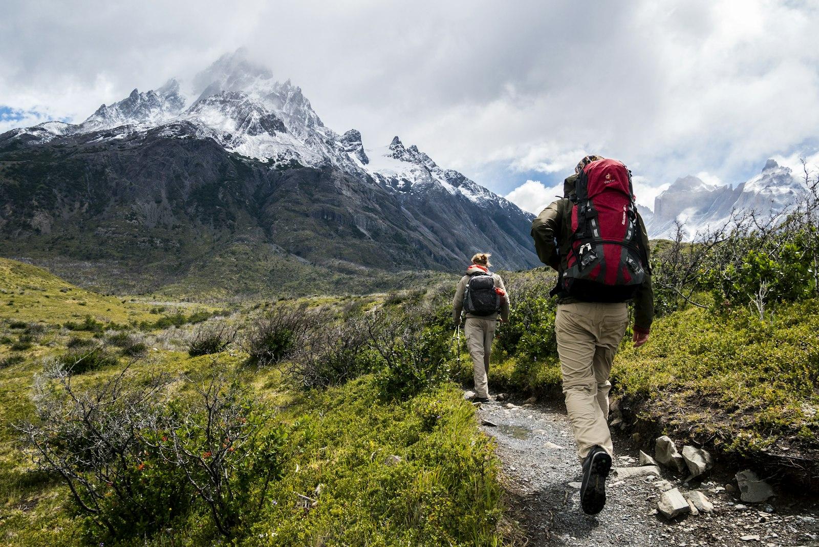 Hiker standing on a mountain trail overlooking a valley