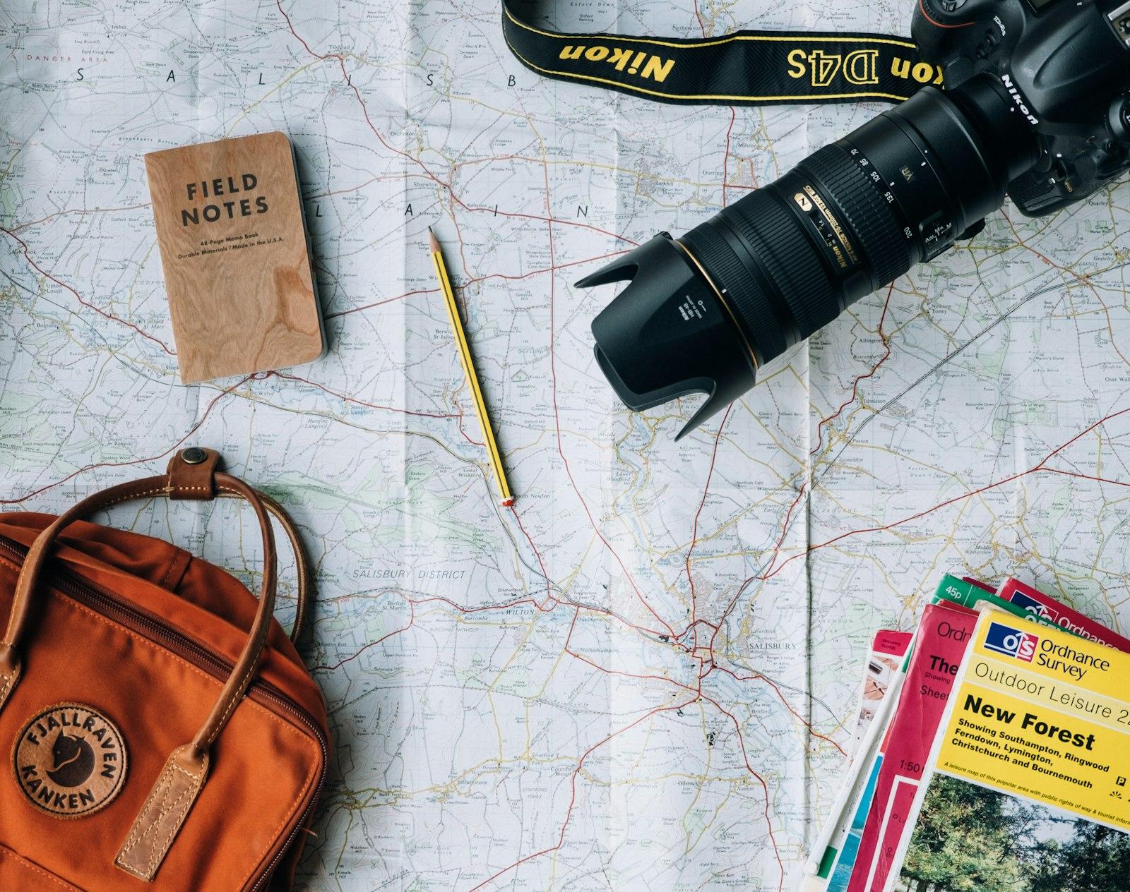 Travel map, camera and backpack laid out for trip planning